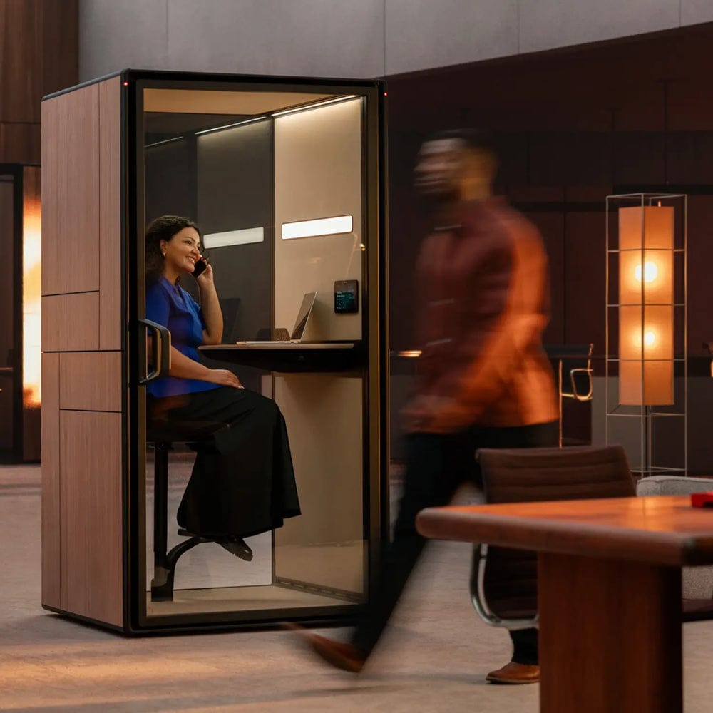 Framery Gradus Focus pod in a lobby, with a person working at the fold-out desk