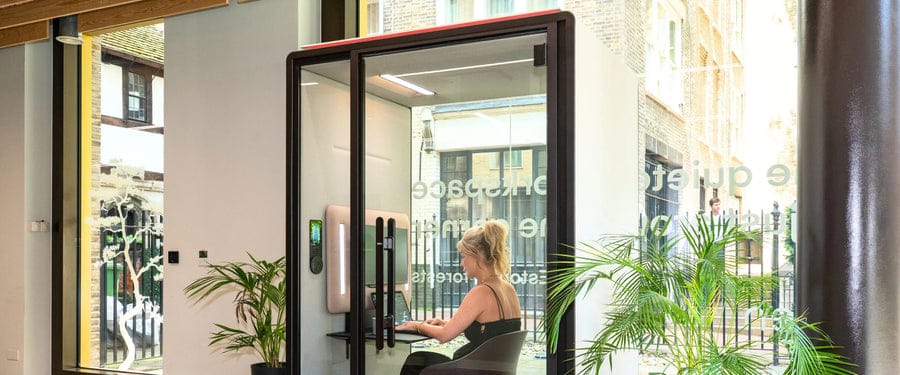 Person working on a laptop inside a Silen Space booth